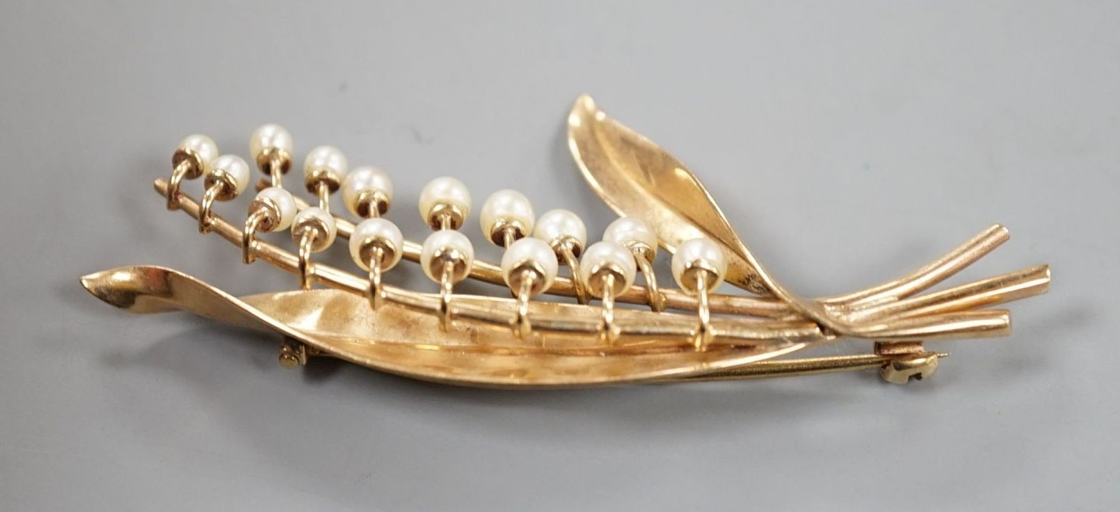 A modern 9ct gold and cultured pearl set spray brooch, 6cm, gross weight 6.7 grams.